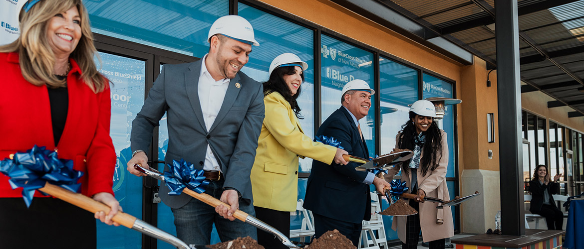 Officials hold ceremonial shovels of dirt for a groundbreaking