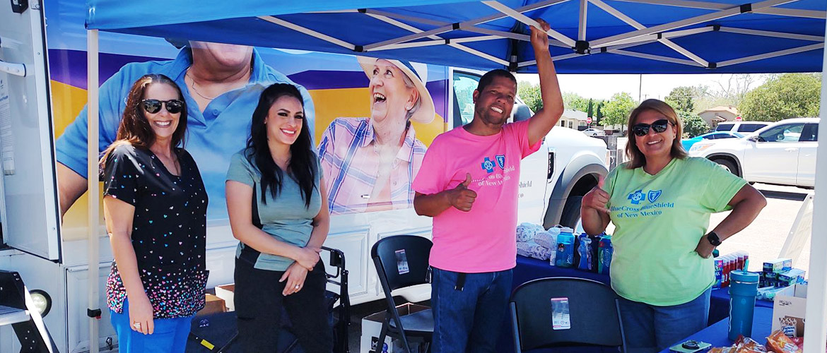 Outreach workers stand under a tent