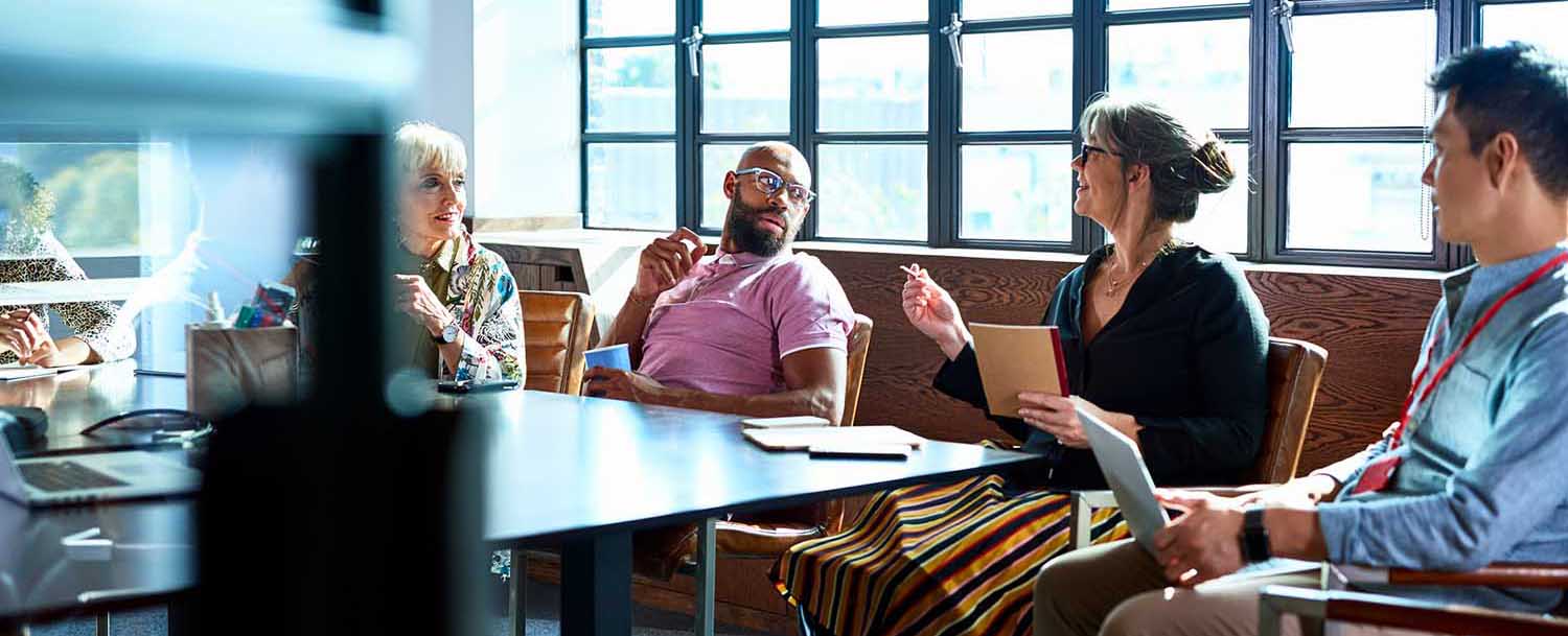 A group of people hold a meeting around a table