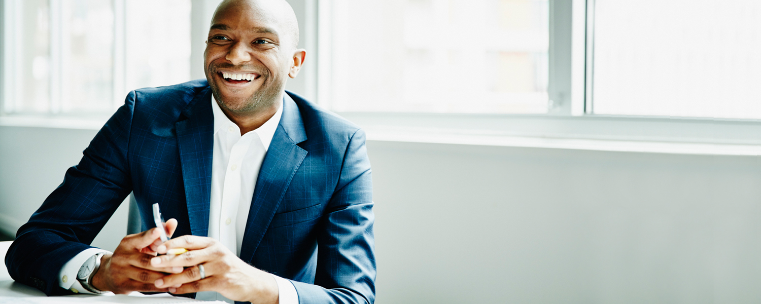 A man in a suit smiles 